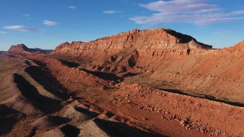 Majestic red rock mountain range under blue sky at sunset aerial view Stock Footage 296428176