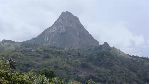 Majestic Sharp Peak Mountain Surrounded by Tropical Forest Under Cloudy Sky. Stock Footage 329503006