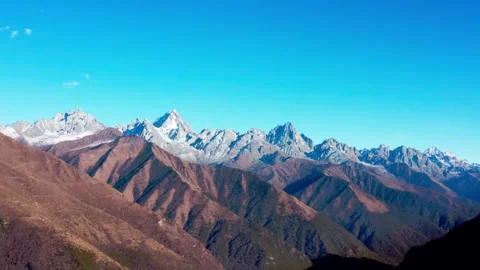 Majestic snowcapped mountain range under a clear blue sky Stock Footage 341908280