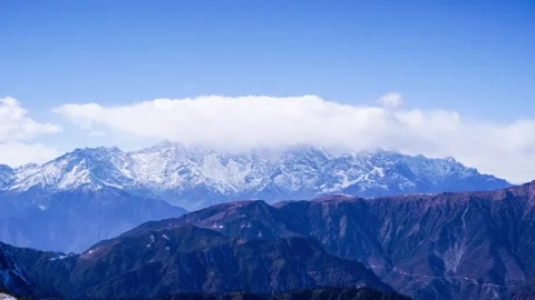 Majestic snowcapped mountain range under a clear blue sky Stock Footage 341939498