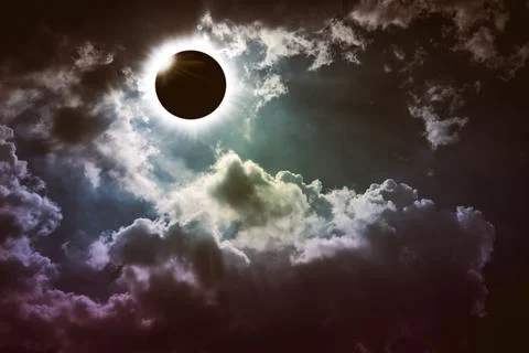 Majestic solar eclipse above cloudy sky Stock Photos