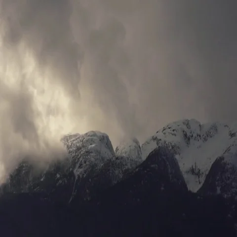 Majestic timelapse of clouds rolling over snow covered mountain peaks Stock Footage 69721600