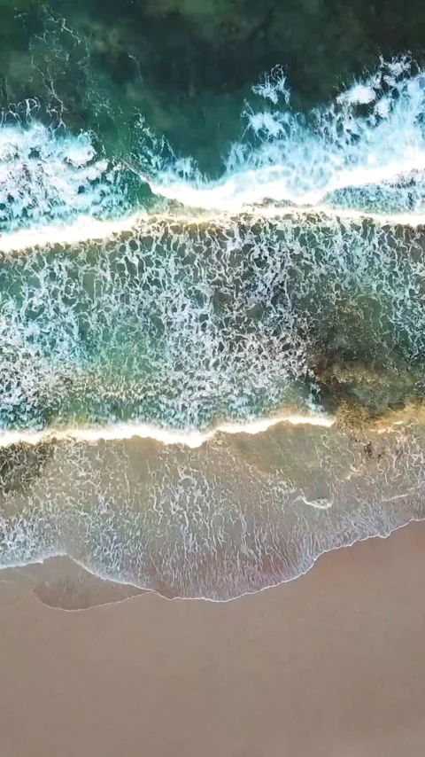 Majestic top-down aerial view of turquoise ocean waves gently rolling and Stock Footage 344839397