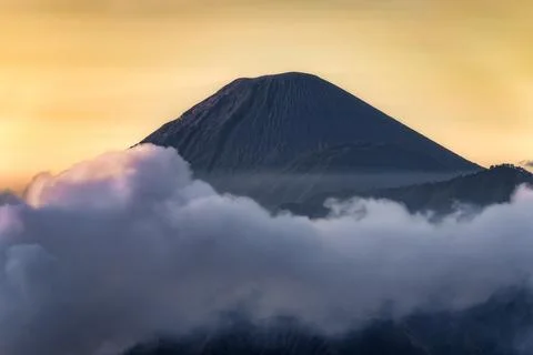 A Majestic Volcano Elegantly Surrounded by Wispy Clouds at Dusk, Creating a.. 스톡 사진