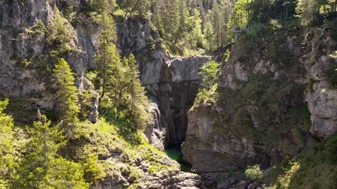 Majestic Waterfall Cascading into a Deep Gorge in the Lechtal Alps Surrounded by Stock Footage 335763704