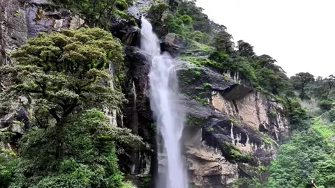 Majestic Waterfall Cascading Down Rocky Cliffs in Lush Mountains Tibet China 動画素材 346737685