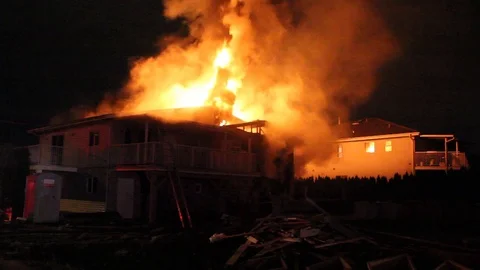 Major house fire at night lets flames pouring out of roof in North America Stock Footage 93616294