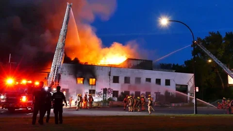 Major vacant building fire with flames, firefighters and officers Video stock 116012862