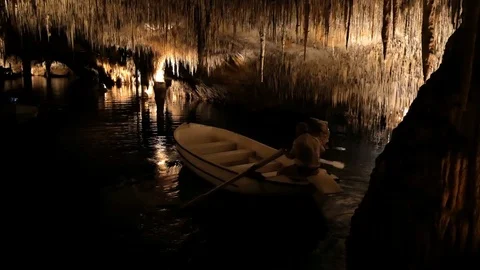 MAJORCA, SPAIN Tourists float on a boat on the underground lake in the famous Stock Footage 86192734