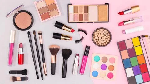 MAke up and cosmetics products pattern on grey and pastel pink background. Fl Stock Photos