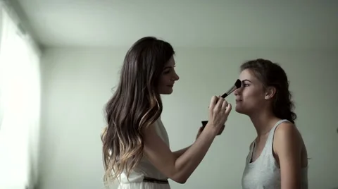 Make-up artist and model in a large white studio. Slow motion Stock Footage 66824199