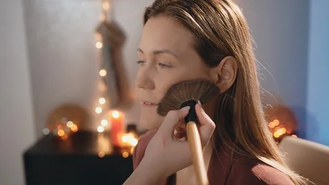 The make-up artist applies a blush with a large professional brush on the face Stock-Footage 101236164