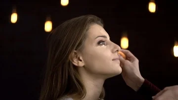 Make-up artist applies blush on the model 스톡 동영상 85756952