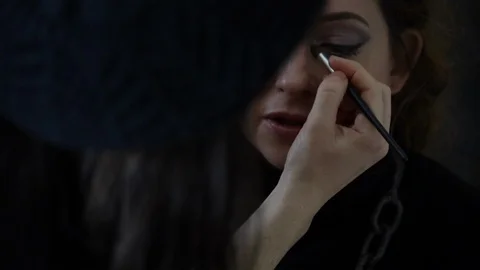 Make up artist applies eye shadow while client talks and smiles Stock-Footage 98757020