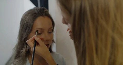 Make-up Artist Applies Eyeshadow Makeup on  Caucasian Woman. Preparation to pers Stock Footage 113065643