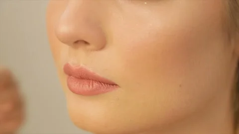 The make-up artist applies a foundation on the face of the model. Stock Footage 87683612