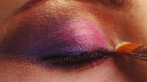 Make-up artist applies makeup to the upper eyelid, close-up.  Makeup artist a Stock Footage 154892539