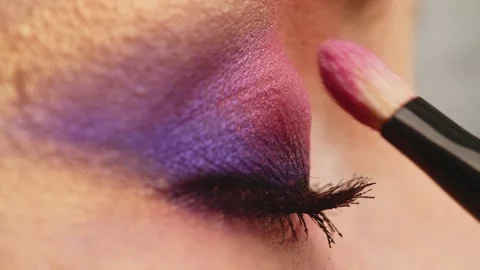 Make-up artist applies makeup to the upper eyelid, close-up.  Makeup artist a Stock Footage 154892560
