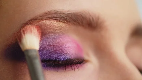 Make-up artist applies makeup to the upper eyelid, close-up.  Makeup artist a Stock Footage 154892617