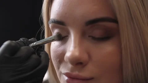 Make-up artist applies makeup to the upper eyelid, close-up.  Stock Footage 198881346