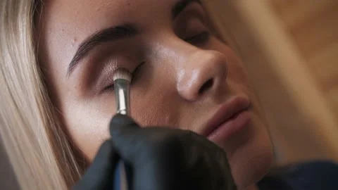 Make-up artist applies makeup to the upper eyelid, close-up.  Stock Footage 198881369