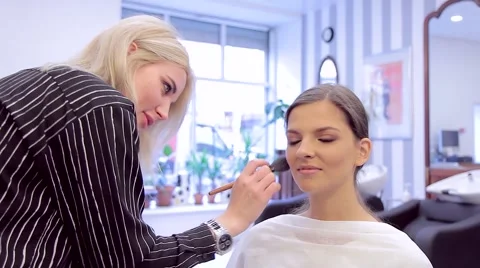 Make-up artist applying brush and powder to model's face Stock Footage 68748067