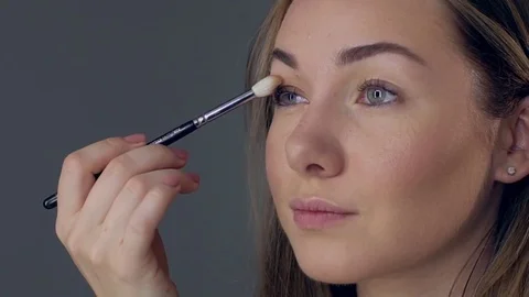Make-up artist applying eye shadow with brush, close up Stock-Footage 75457764