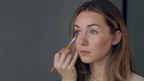 Make-up artist applying eye shadow with brush, close up Stock Footage 75457854