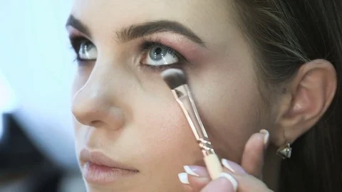 Make-up artist applying eyelash makeup to model's eye. Close up view. Stock Footage 70667209