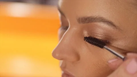 Make-up artist applying eyelash makeup to model's eye. Close up view. Stock Footage 87525274