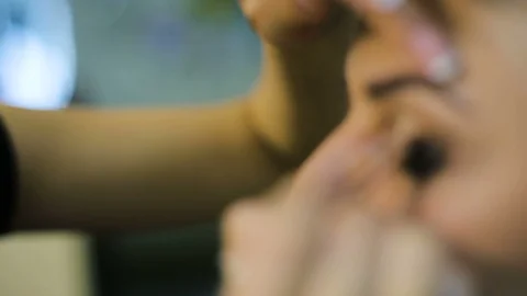 Make-up artist applying eyelash makeup to model's eye. Close up view. Stock Footage 96023968