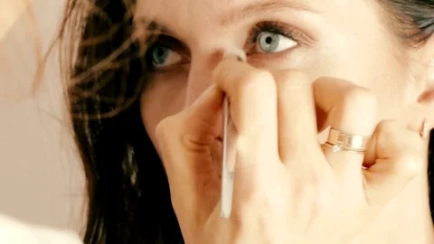 Make-up artist applying eyes make-up to an adult woman model 스톡 동영상 82739045