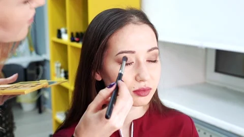 Make-up artist applying eyeshadow to the model. Stock Footage 103388740