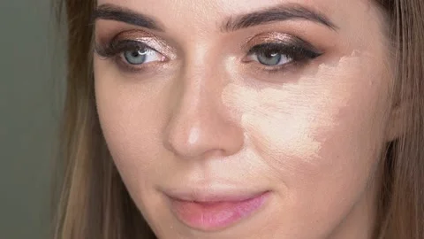 Make-up artist applying foundation on the face of a woman by brush Stockbeeldmateriaal 154964799