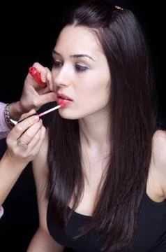 Make-up artist applying gloss on lips Stock Photos