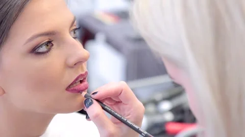 Make-up artist applying the lip pencil to model's lips Stock Footage 68748968