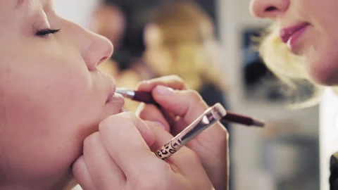 Make up artist applying lipstick. Closeup of the lips of a young woman, profe Stock Footage 219932848