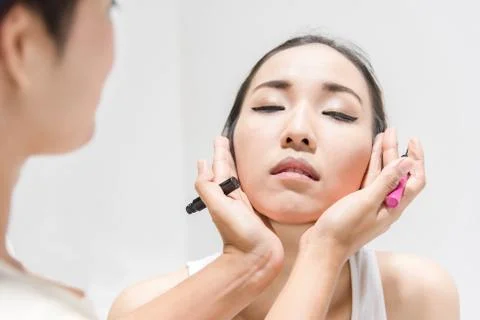 Make up artist applying make up to clean face a fashion model or bride Stock Photos