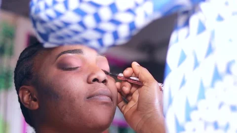 Make up artist applying make up on eye brow of a woman. Brushing over eyebrow Stock Footage 217874636