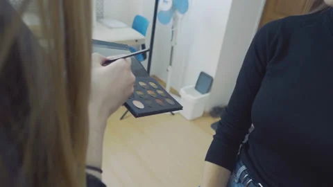 Make-up artist applying make-up on model Stock Footage 90797135