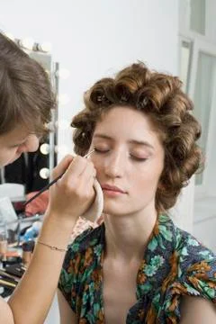 A make-up artist applying make-up on a model Stock Photos