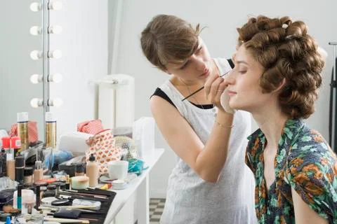 A make-up artist applying make-up on a model Stock Photos