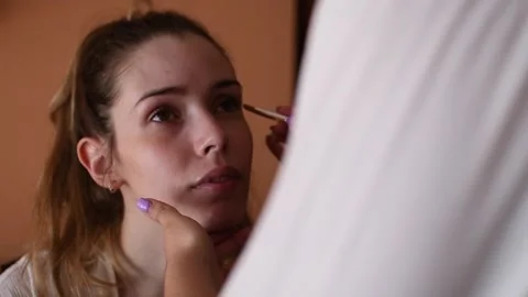 Make-up artist applying makeup to a young model in a makeup studio. type of s Stock Footage 134561714