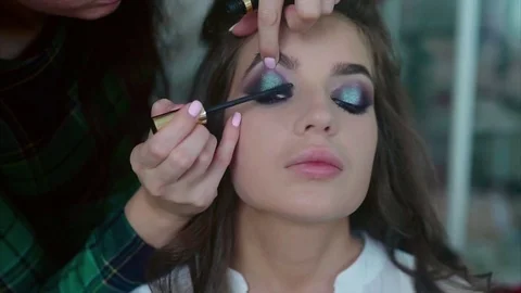 Make up artist applying on mascara on model's eyes Stock Footage 70138080