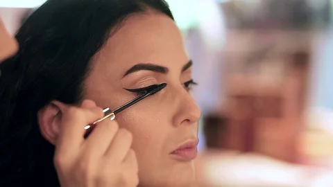 Make up artist applying mascara on model's eyelashes in slow motion Stock Footage 76081942