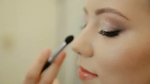 Make-up artist applying powder on client's nose with professional brush Stock Footage 131335013