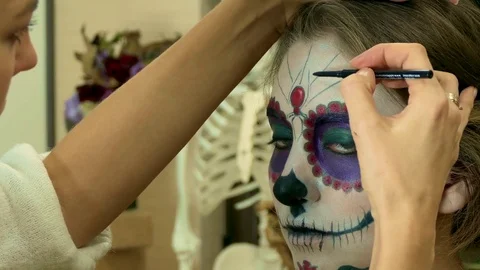 Make-up artist applying sugar skull mexican make up Stock Footage 82720273
