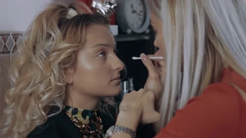 The make-up artist cleans the inside of the eye with a cotton swab. The process Video stock 157445309