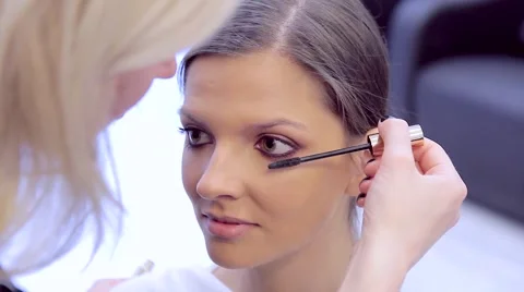 Make-up artist coats model's eyelashes with mascara Video stock 68747141
