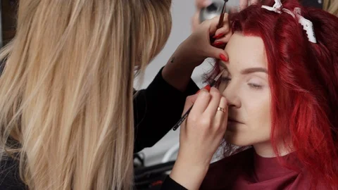 Make-up artist color eyebrows to client, close-up Stock-Footage 88181760